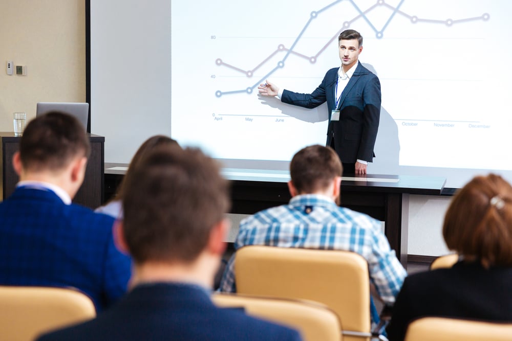 Intelligent speaker standing and lecturing at business conference in boardroom